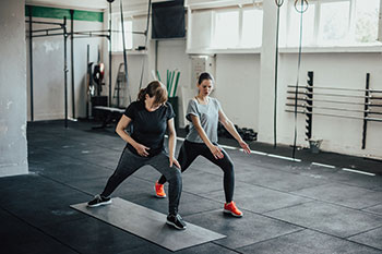 Woman doing yoga with trainer