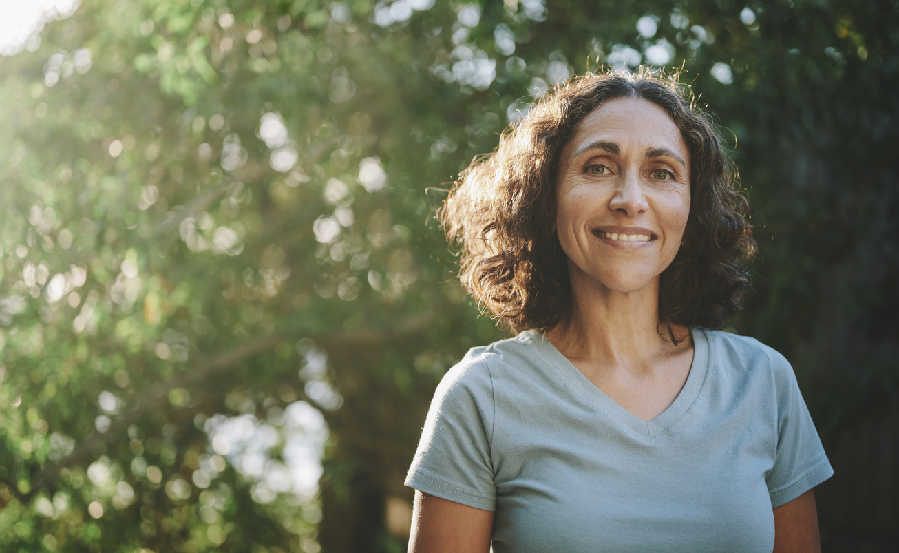 Smiling BHRT patient walks outside as part of a healthy lifestyle routine